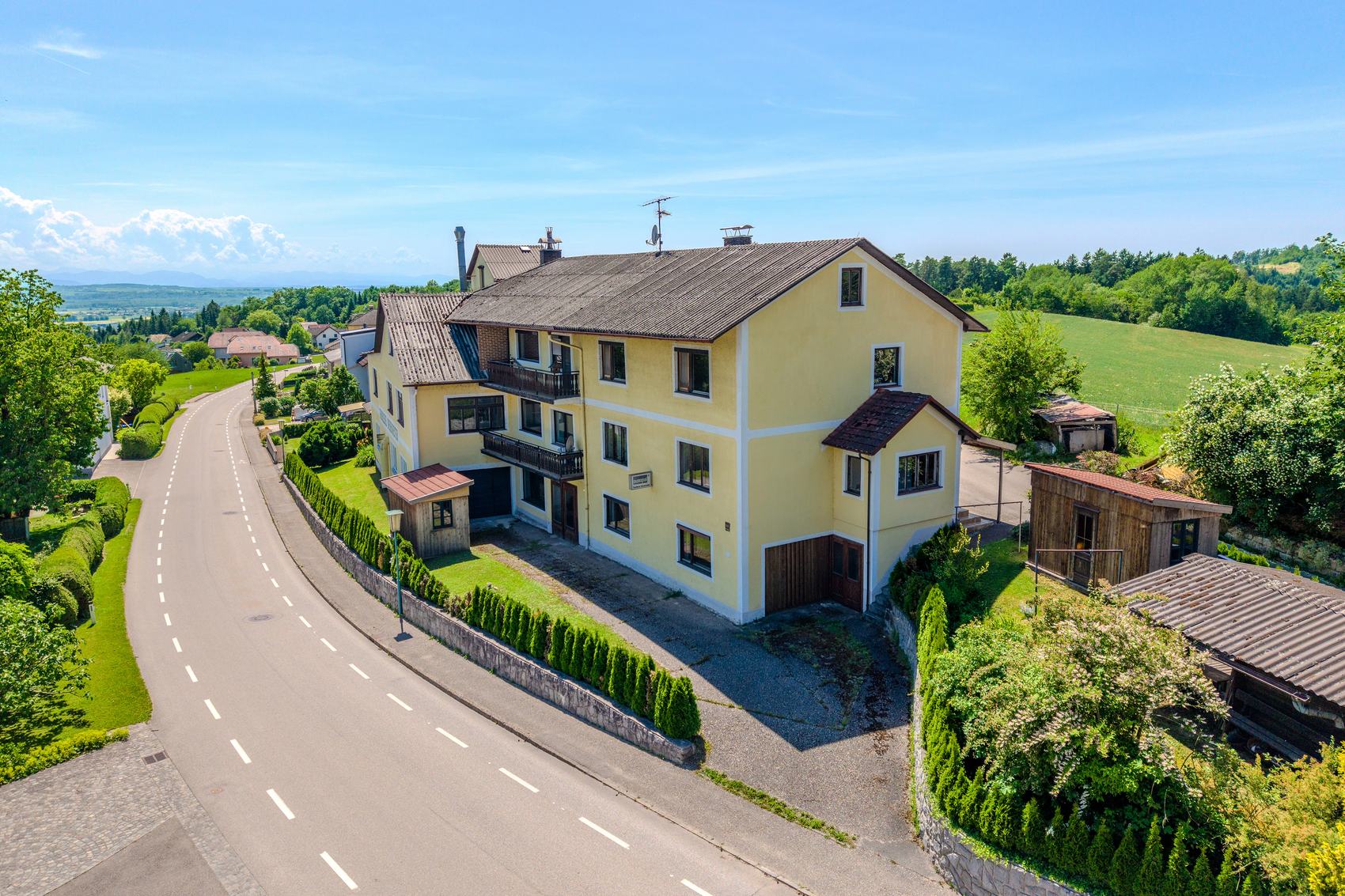 Luftaufnahme eines Wohnhauses mit Nebengebäude an einer Landstraße