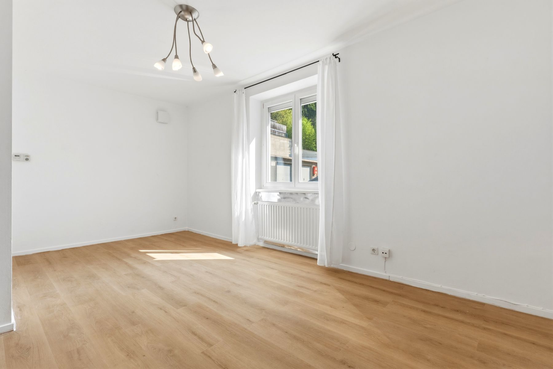 Heller Wohnraum mit Fenster zum Innenhof