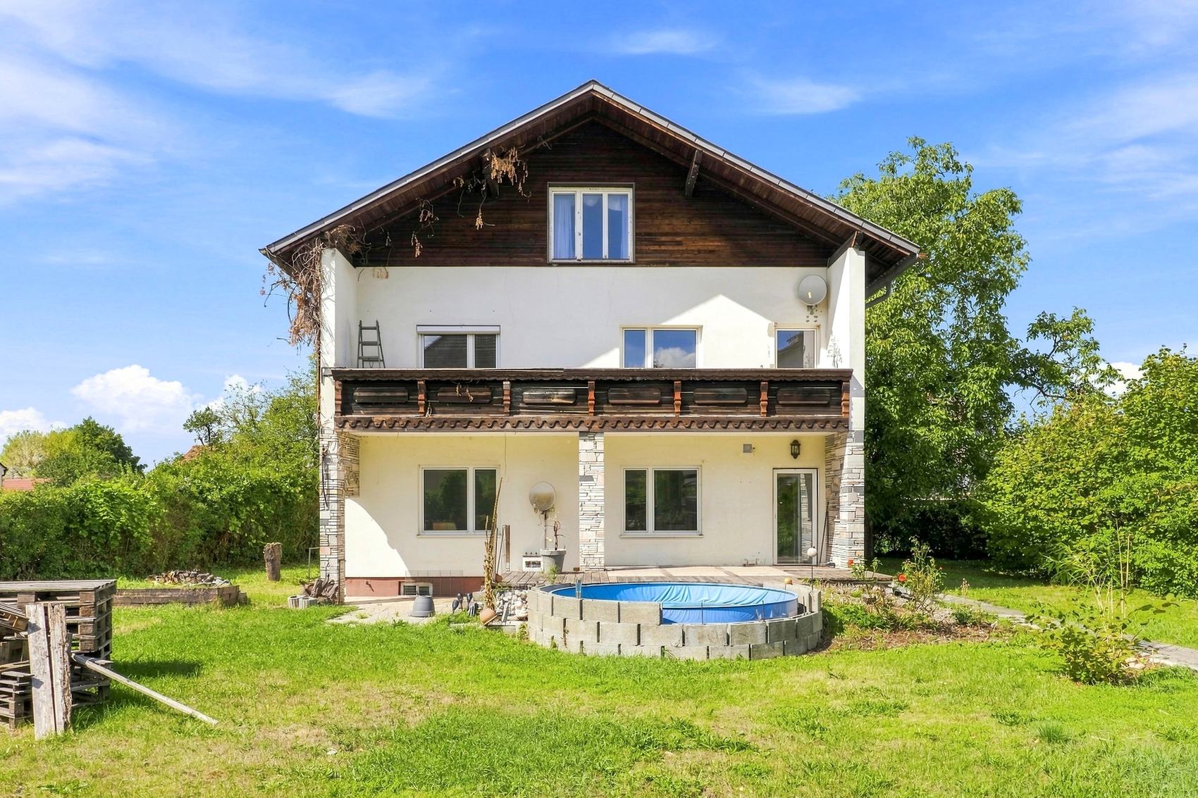 Einfamilienhaus mit Holzfassade im Obergeschoss und Garten