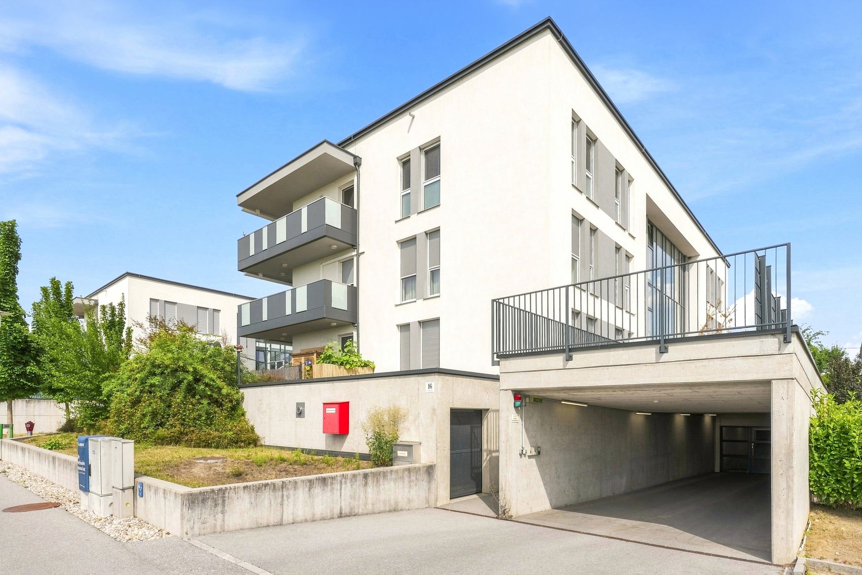 Modernes Wohngebäude mit Balkonen und Tiefgarageneinfahrt