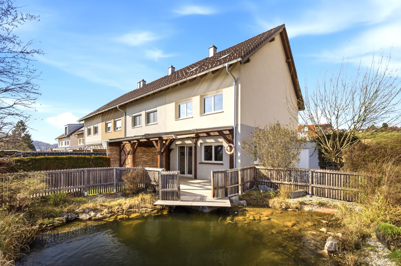 Reihenhäuser von hinten mit Teich und Holzsteg