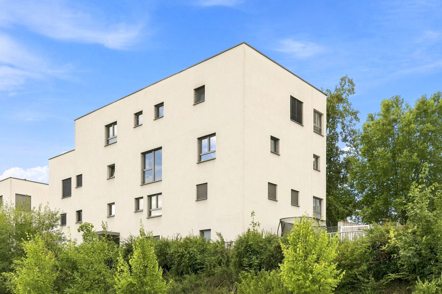 Modernes Wohngebäude hinter Bäumen