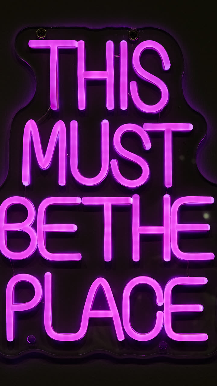 Pinkfarbene Leuchtschrift "This must be the place" bei einer Abendveranstaltung